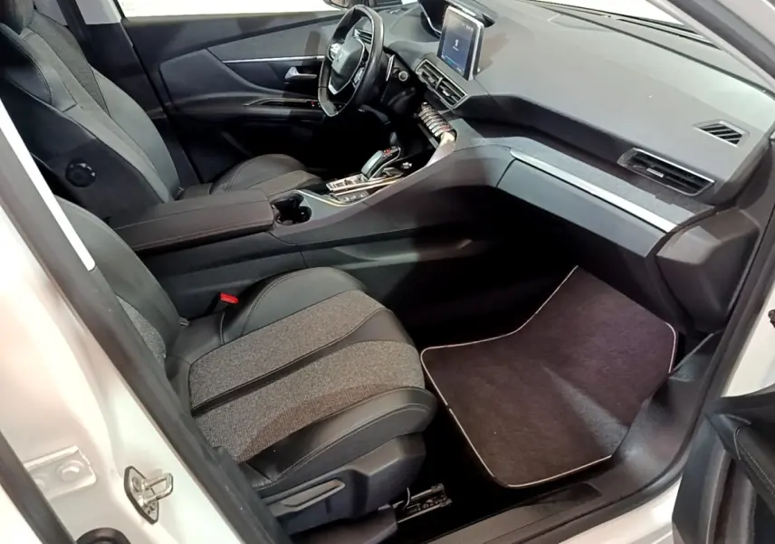 Vue intérieure côté passager avant du Peugeot 3008 blanc, avec sièges bi-matière et tableau de bord moderne.