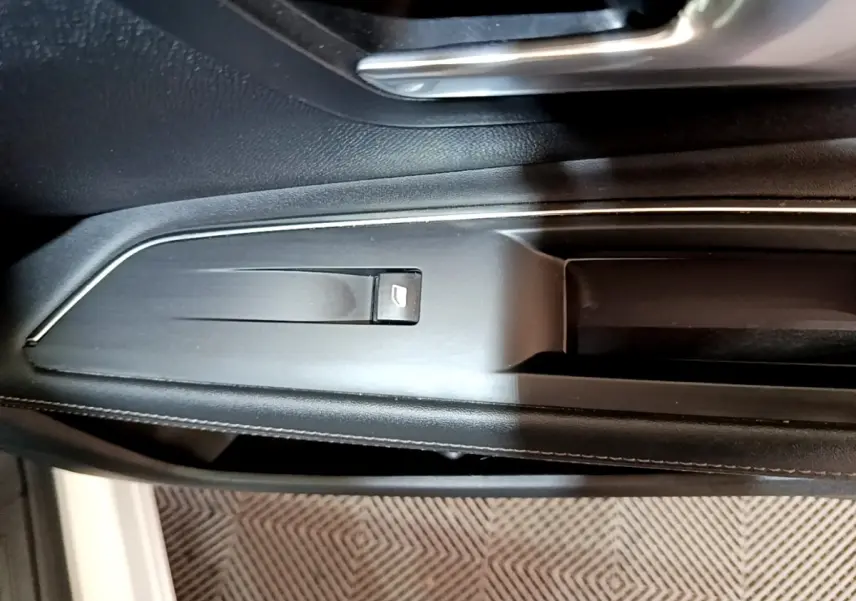 Détail de la commande de lève-vitre côté gauche intérieur du Peugeot 3008 blanc hybride rechargeable.