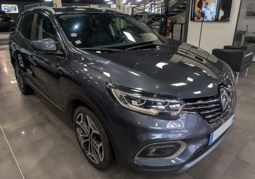 Vue 3/4 avant droit du Renault Kadjar gris titanium, mettant en valeur ses phares LED et ses jantes alliage au design moderne.