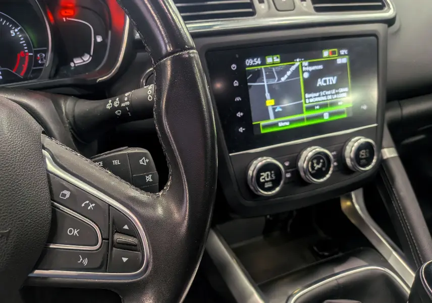 Vue intérieure rapprochée du tableau de bord et volant noir du Renault Kadjar TCe 140, avec écran tactile et commandes au volant.
