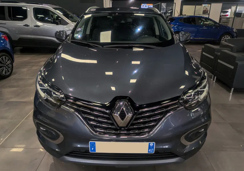 Vue de face d’un Renault Kadjar TCe 140 Intens gris titanium, mettant en valeur sa calandre chromée et ses phares LED.