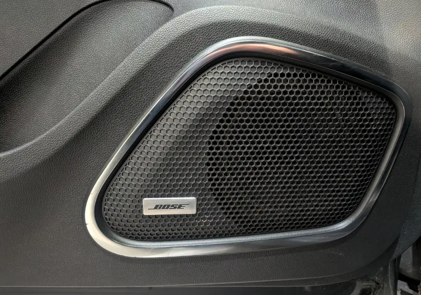 Gros plan sur l'enceinte Bose intégrée dans la porte intérieure noire du Renault Kadjar TCe 140 Gris Titanium.