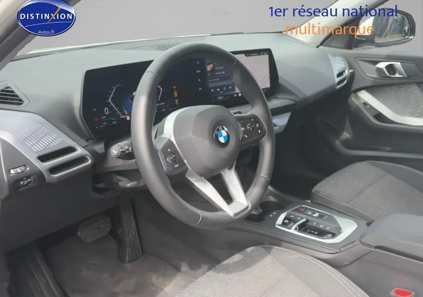 Vue intérieure côté conducteur de la BMW Série 1 120da 2025, volant cuir et tableau de bord numérique.
