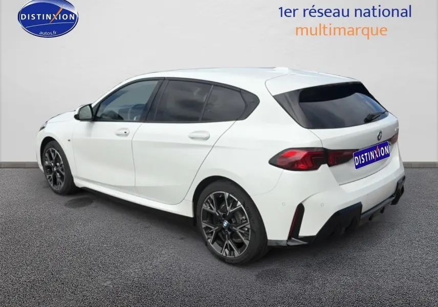 BMW Série 1 blanche vue 3/4 arrière droit, jantes noires et vitres teintées sur fond neutre.