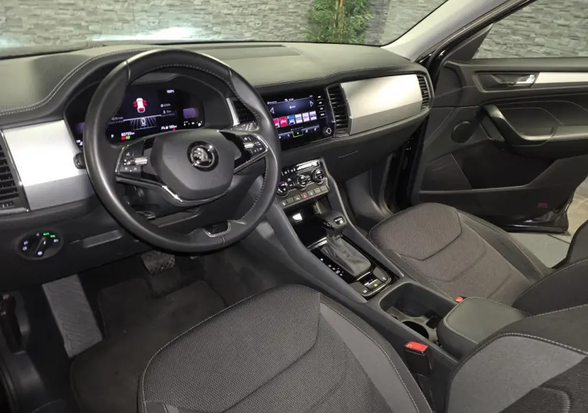 Intérieur noir du Skoda Kodiaq 2023 vu côté conducteur, avec tableau de bord digital et console centrale moderne.