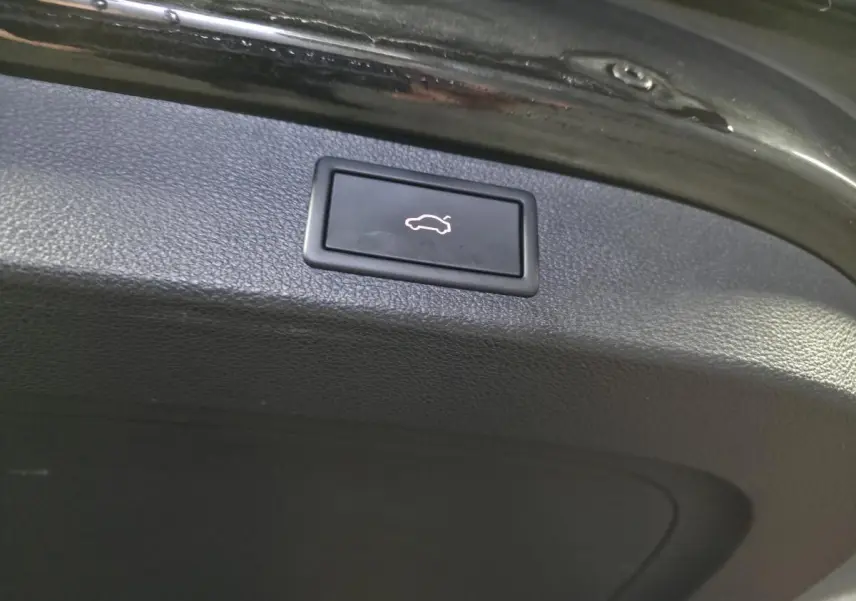 Gros plan sur le bouton d'ouverture électrique du coffre d'un Skoda Kodiaq noir, version 2023 Ambition.