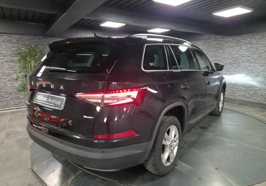 Vue 3/4 arrière droite du Skoda Kodiaq noir 2023 avec feux arrière LED allumés dans un garage.