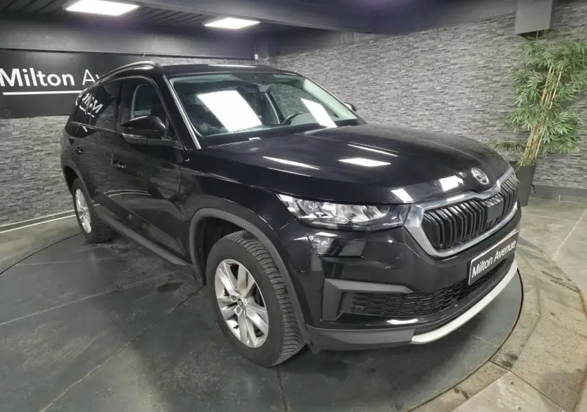 Vue 3/4 avant gauche d'un SUV Skoda Kodiaq noir métallisé avec calandre chromée et jantes alliage 17 pouces.
