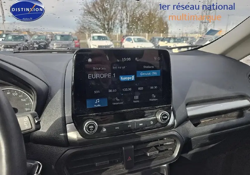 Vue intérieure centrée sur l’écran tactile du tableau de bord d’un Ford Ecosport gris, avec volant partiel visible à gauche.