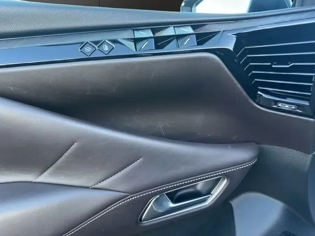 Détail de la porte avant droite en cuir noir du DS4 2022 avec commandes de verrouillage et finition soignée.