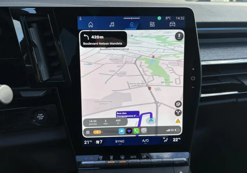 Vue rapprochée de l’écran tactile central du Renault Austral blanc nacré affichant la navigation GPS et les commandes climatisation.