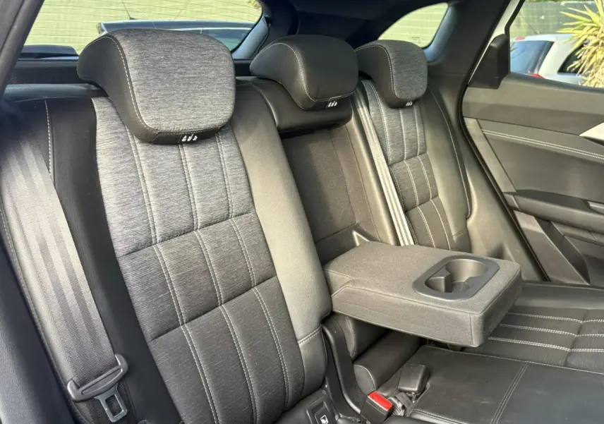 Vue intérieure des sièges arrière gris dégradé du Renault Austral E-Tech avec accoudoir central et porte-gobelets déployé.