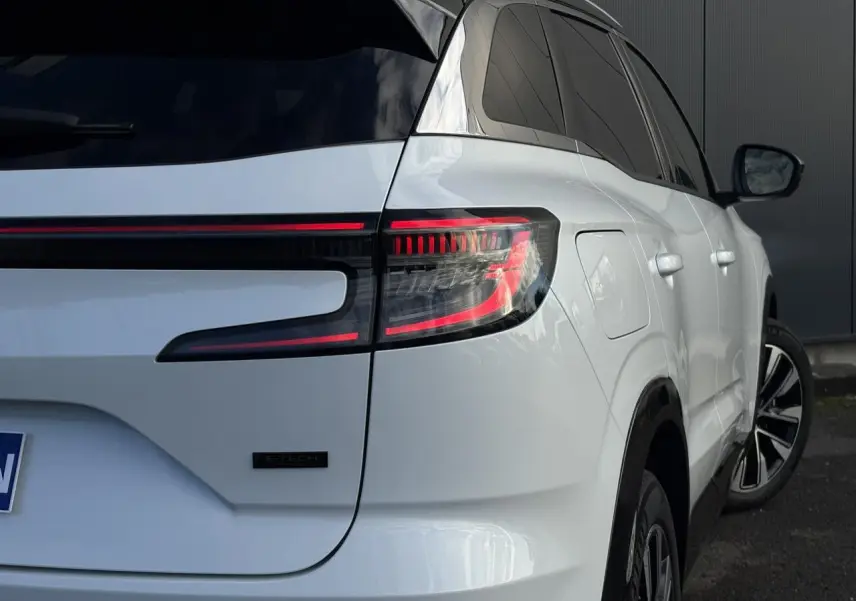 Vue 3/4 arrière droite du Renault Austral blanc nacré avec feux arrière LED et badge E-Tech visible.