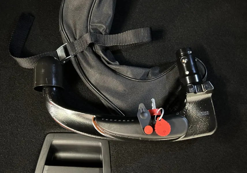 Attelage amovible noir avec clé et housse de protection sur fond de moquette noire, accessoire pour Peugeot 3008 bleu.