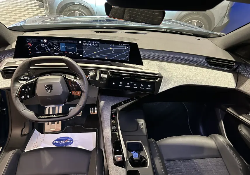 Vue intérieure avant du Peugeot 3008 III Hybrid 145 GT, tableau de bord numérique large et volant compact multifonction.