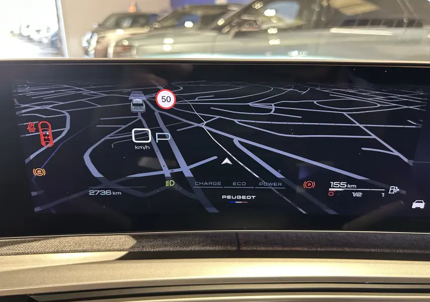 Affichage numérique du tableau de bord du Peugeot 3008 III Hybrid 145, montrant la navigation et les indicateurs de conduite.