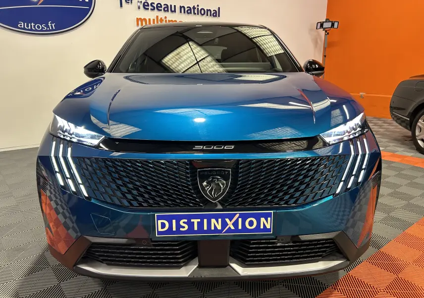 Vue frontale du Peugeot 3008 III Hybrid 145 GT bleu obsession avec calandre noire et feux LED distinctifs allumés.