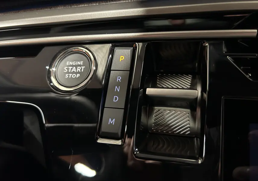 Gros plan intérieur sur le bouton start/stop et la commande de boîte automatique du Peugeot 3008 III Hybrid 2025.