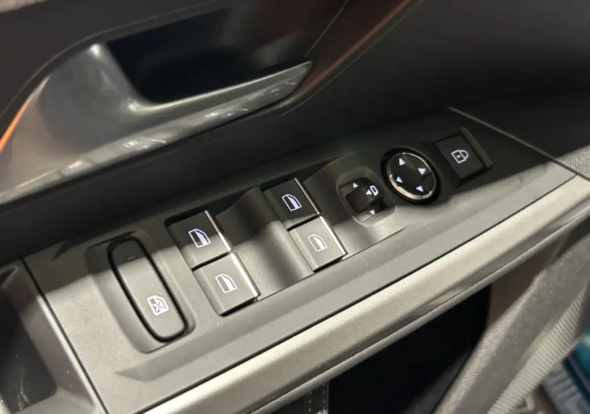 Gros plan sur les commandes de lève-vitres et rétroviseurs côté conducteur du Peugeot 3008 III Hybrid bleu Obsession.
