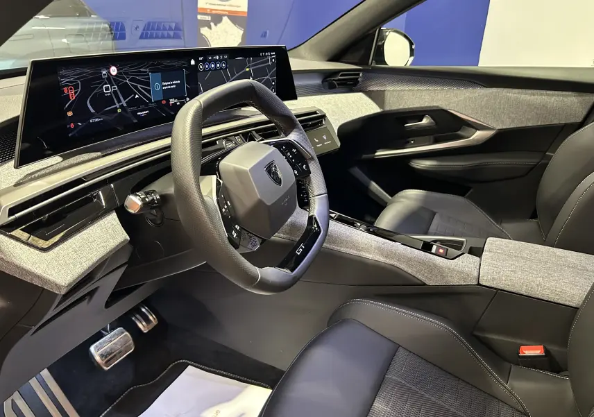 Intérieur du Peugeot 3008 III Hybrid 145 GT, vue côté conducteur, volant GT, tableau de bord numérique large.