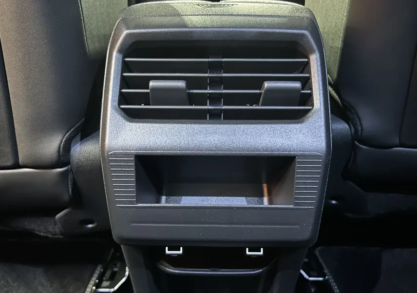 Détail de la console arrière noire avec bouches d'aération et ports USB du Peugeot 3008 III Hybrid 2025.