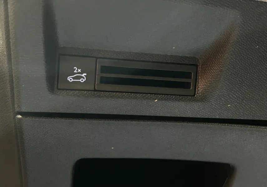 Bouton intérieur noir avec symbole d'ouverture du coffre sur Peugeot 3008 III Hybrid 145 e-DCS6 GT.