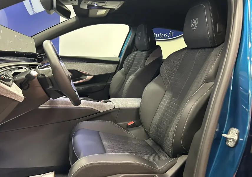 Vue intérieure côté conducteur du Peugeot 3008 Bleu Obsession, sièges sport avec logo Peugeot brodé sur les appuie-têtes.