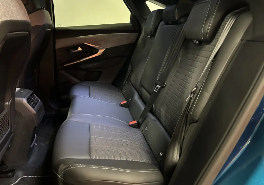 Vue intérieure côté droit des sièges arrière en cuir noir du Peugeot 3008 III HYBRID 145 e-DCS6 GT bleu obsession.
