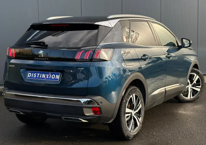 Vue 3/4 arrière droite du Peugeot 3008 GT bleu Célèbes avec toit noir et jantes alliage bi-ton diamantées.