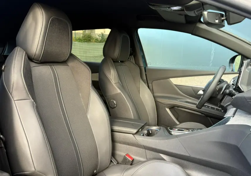 Vue intérieure côté droit du Peugeot 3008 GT 2023 montrant les sièges Mi-TEP/tissu Belomka gris et l'accoudoir central fermé.