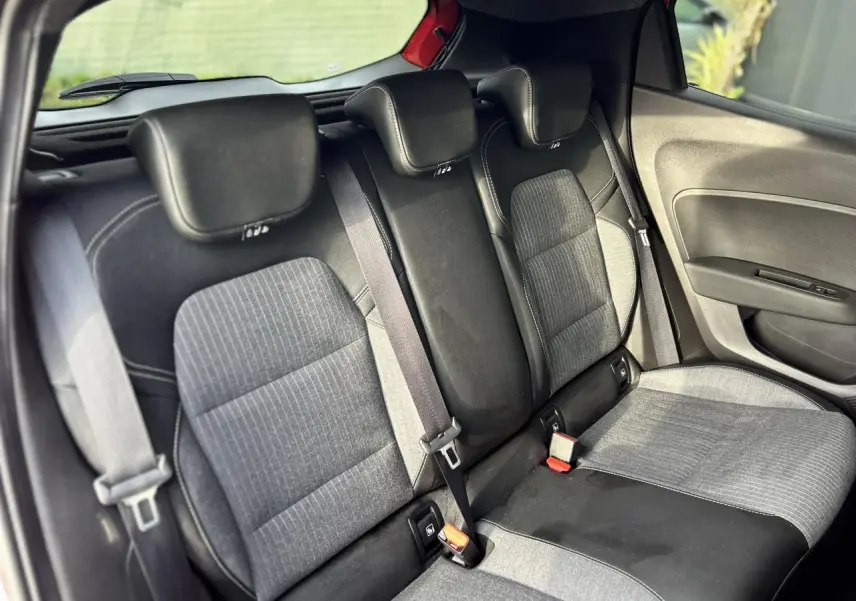 Vue intérieure côté droit sur la banquette arrière grise et noire de la Renault Clio 2025, avec ceintures de sécurité visibles.