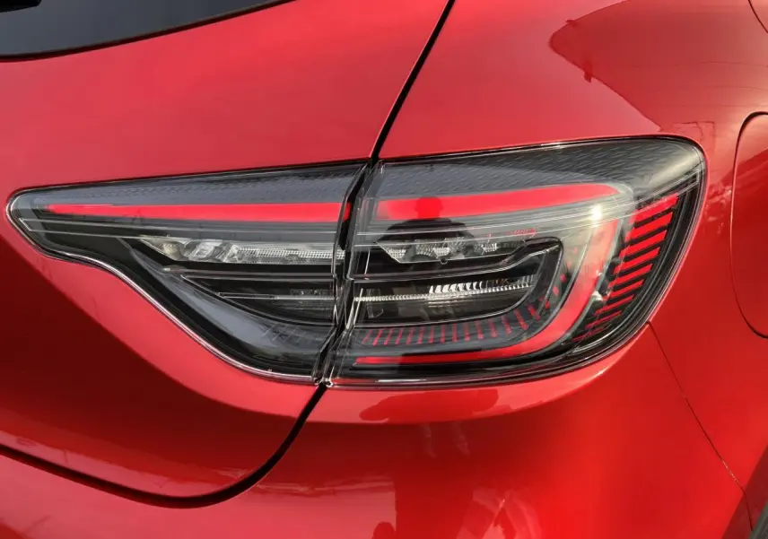 Gros plan sur le feu arrière droit de la Renault Clio 2025 Rouge Désir avec signature lumineuse LED en forme de C.