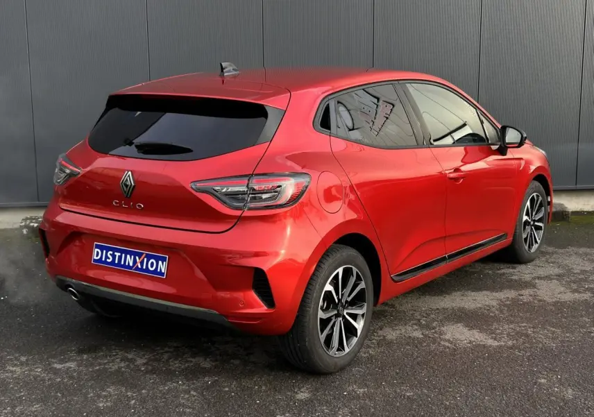 Vue 3/4 arrière droite d'une Renault Clio Rouge Désir avec jantes alliage et vitres surteintées.
