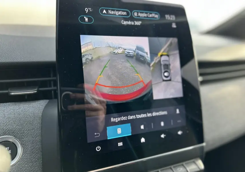 Écran tactile intérieur de la Renault Clio Rouge Désir montrant la caméra 360° en mode recul avec guidage.