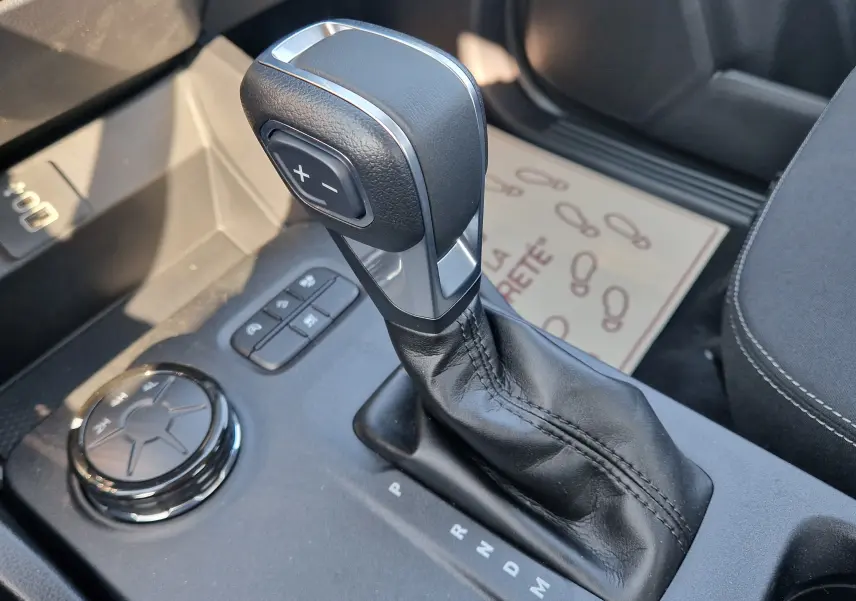 Gros plan sur la commande de boîte automatique et le sélecteur de modes du Ford Ranger Super Cabine gris Iconic, intérieur noir.