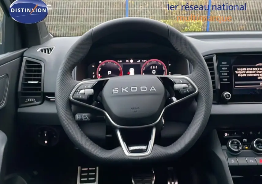 Vue centrée sur le volant SKODA KAROQ 2025 gris argent, tableau de bord digital et écran multimédia visible.