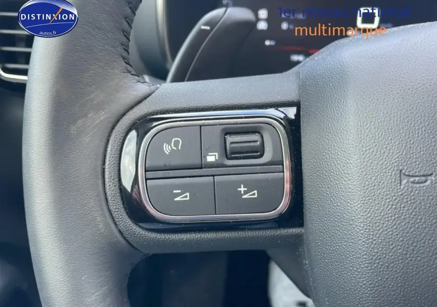 Gros plan sur les commandes gauche du volant cuir noir du Citroën C5 Aircross hybride 2025.