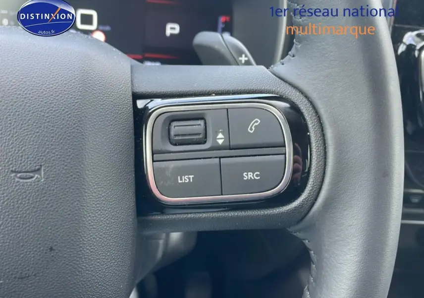 Gros plan sur les commandes gauche du volant cuir noir du Citroën C5 Aircross 2025, avec boutons multifonctions.