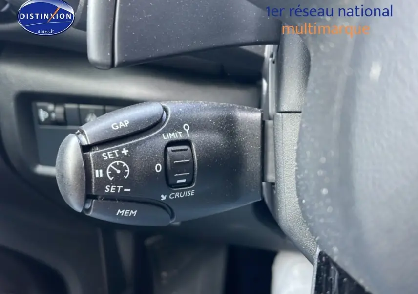 Gros plan sur la commande de régulateur de vitesse au volant d'une Citroën C5 Aircross noire, intérieur visible.