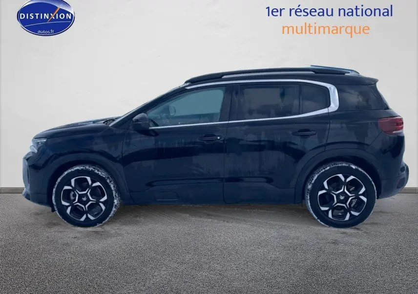 Profil côté gauche d'un Citroën C5 Aircross noir 2025 avec jantes alu et barres de toit visibles.
