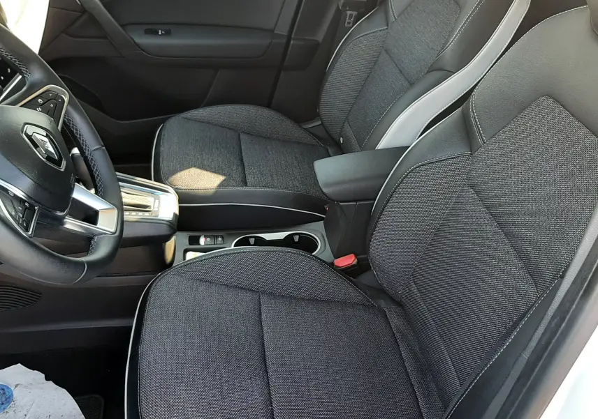 Vue intérieure côté conducteur du Renault Captur E-Tech 145ch Intens 2022, sièges tissu noir avec surpiqûres blanches.