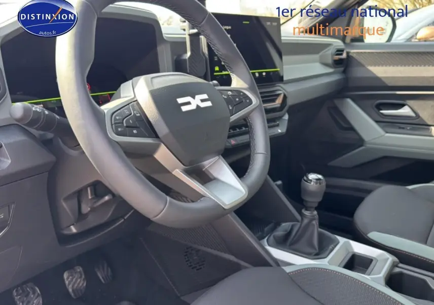 Vue intérieure avant du Dacia Bigster gris schiste, montrant le volant multifonction, la boîte manuelle et l’écran tactile central.