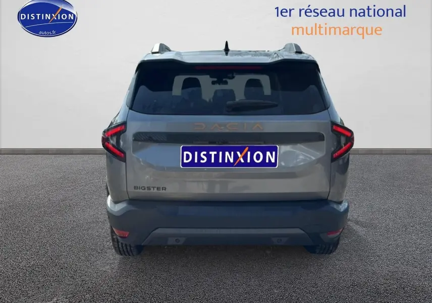 Vue arrière du Dacia Bigster gris schiste avec feux LED en forme de C et hayon électrique visible.
