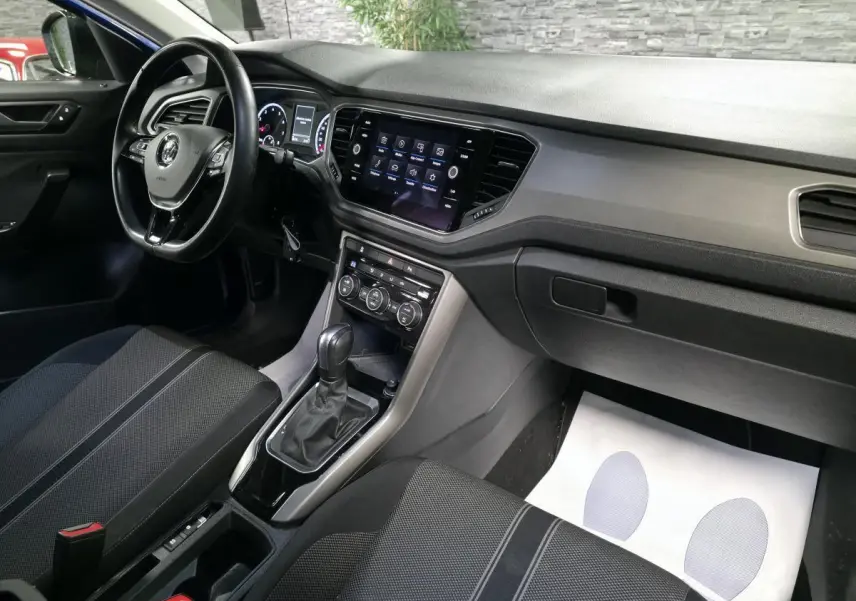 Intérieur avant droit du Volkswagen T-Roc 2020, tableau de bord noir avec écran tactile et sellerie tissu sombre.