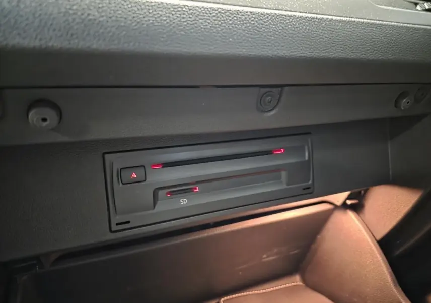 Gros plan sur le lecteur SD et CD dans la boîte à gants du Volkswagen T-Roc 1.5 TSI Evo bleu foncé, intérieur noir.