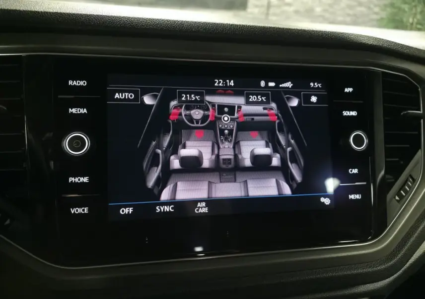 Écran tactile central affichant la vue intérieure du Volkswagen T-Roc avec réglages climatisation bi-zone.