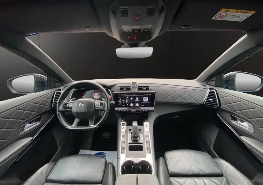 Vue intérieure avant du DS7 Crossback bleu, tableau de bord et volant cuir noir avec surpiqûres losanges.