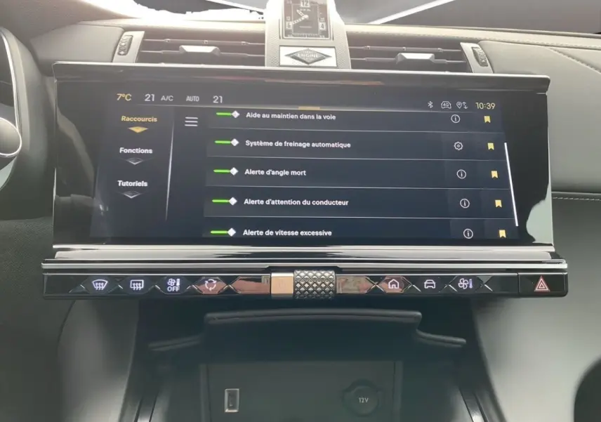 Vue rapprochée de l’écran tactile central du DS7 Crossback bleu, affichant les aides à la conduite et les commandes tactiles.