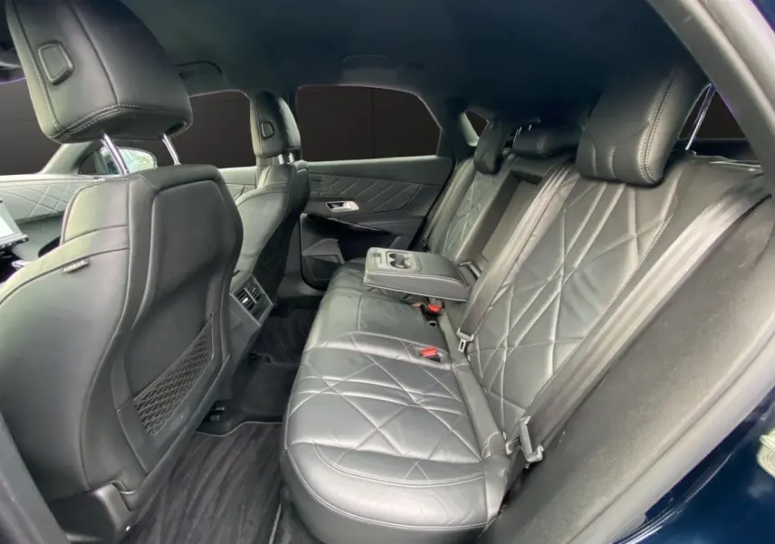 Vue intérieure côté droit des sièges arrière en cuir noir matelassé du DS7 Crossback bleu, avec accoudoir central déployé.
