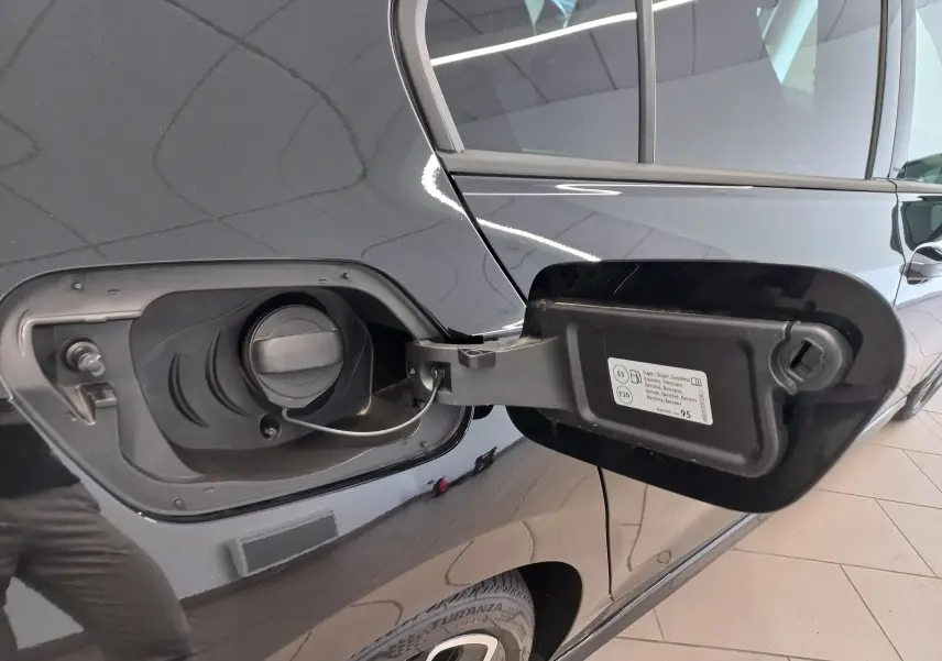 Vue rapprochée du côté gauche arrière d’une Volkswagen Golf 1.5 eTSI noire avec trappe à carburant ouverte.